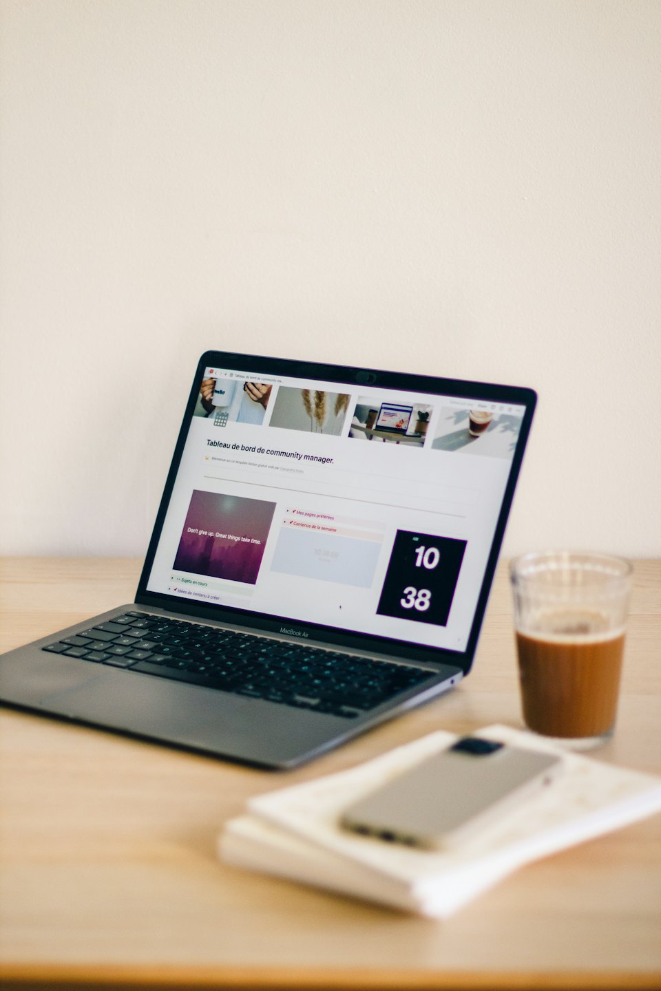 Laptop mit Dashboard auf einem Holztisch mit Eiskaffee.