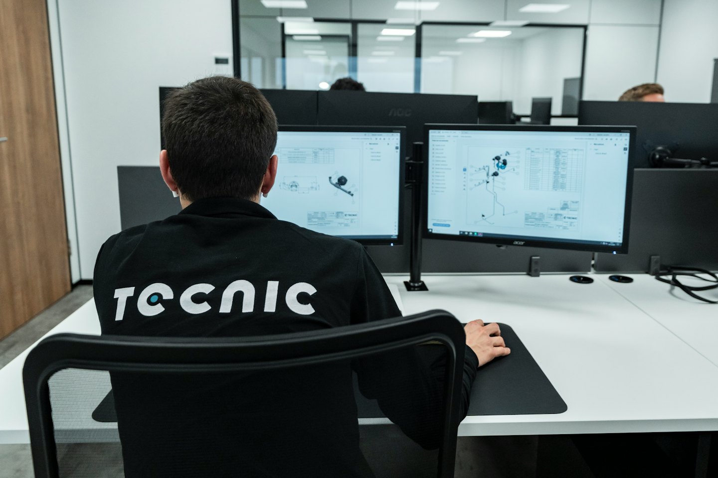 Professioneller Mitarbeiter arbeitet an CAD-Software an einem Dual-Monitor-Arbeitsplatz.