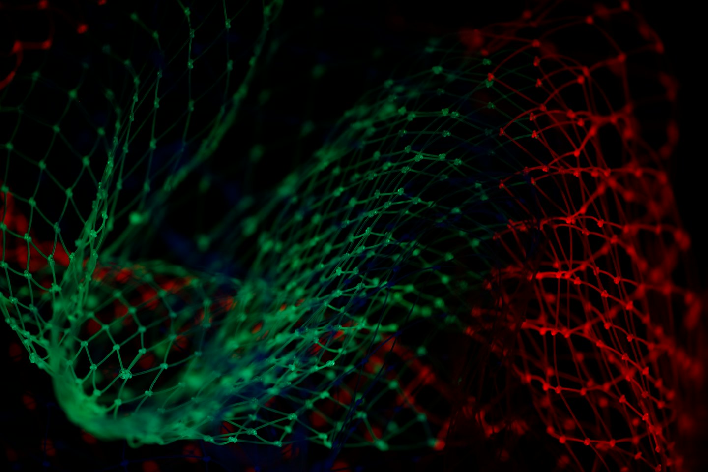 Leuchtendes grünes und rotes digitales Netzwerk auf schwarzem Hintergrund.